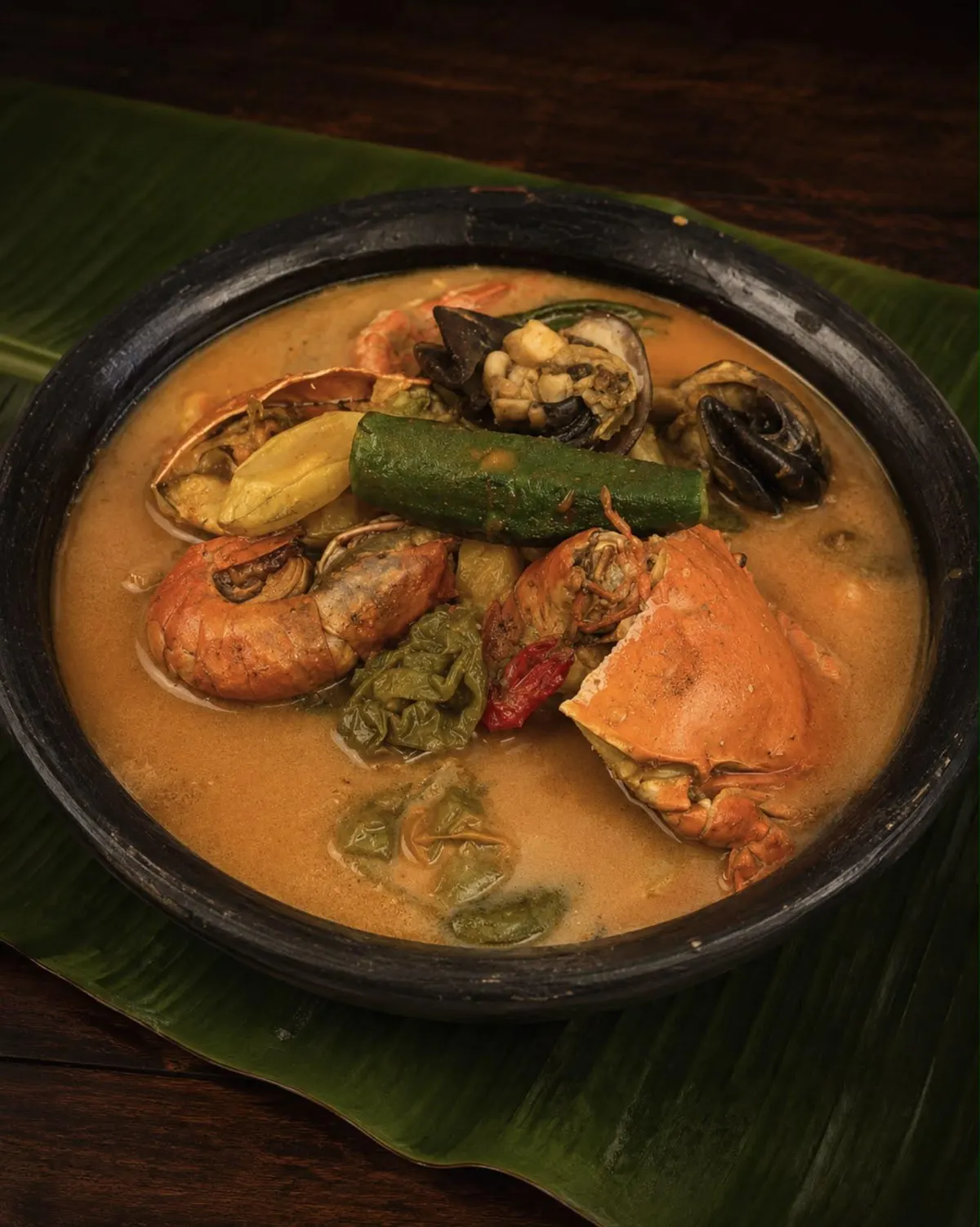 Soupe de fruits de mer en canari : crabe, crevettes et gombo sur feuille de bananier
