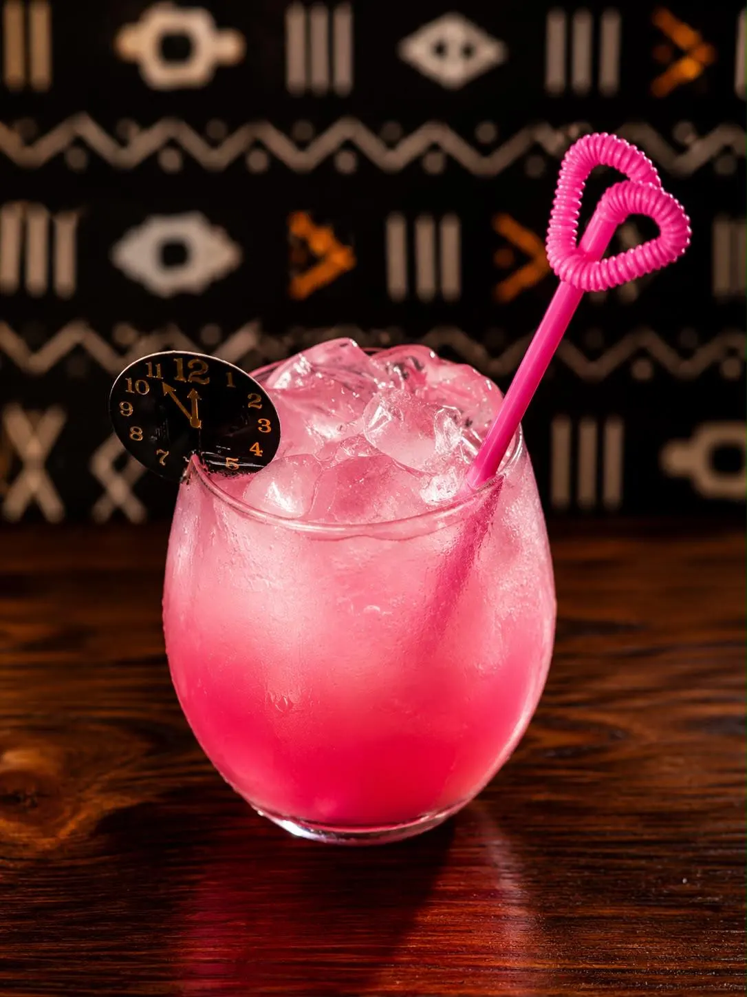 Cocktail rose sur glace pilée, paille en forme de cœur
