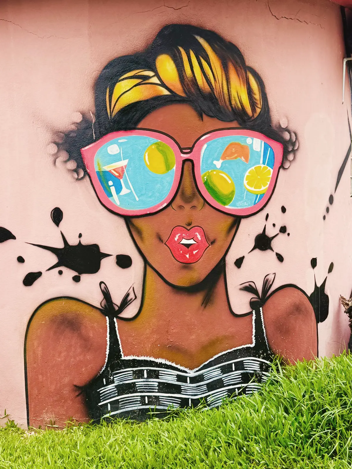 Fresque murale peinte : un visage de femme aux lunettes de soleil reflétant des fruits