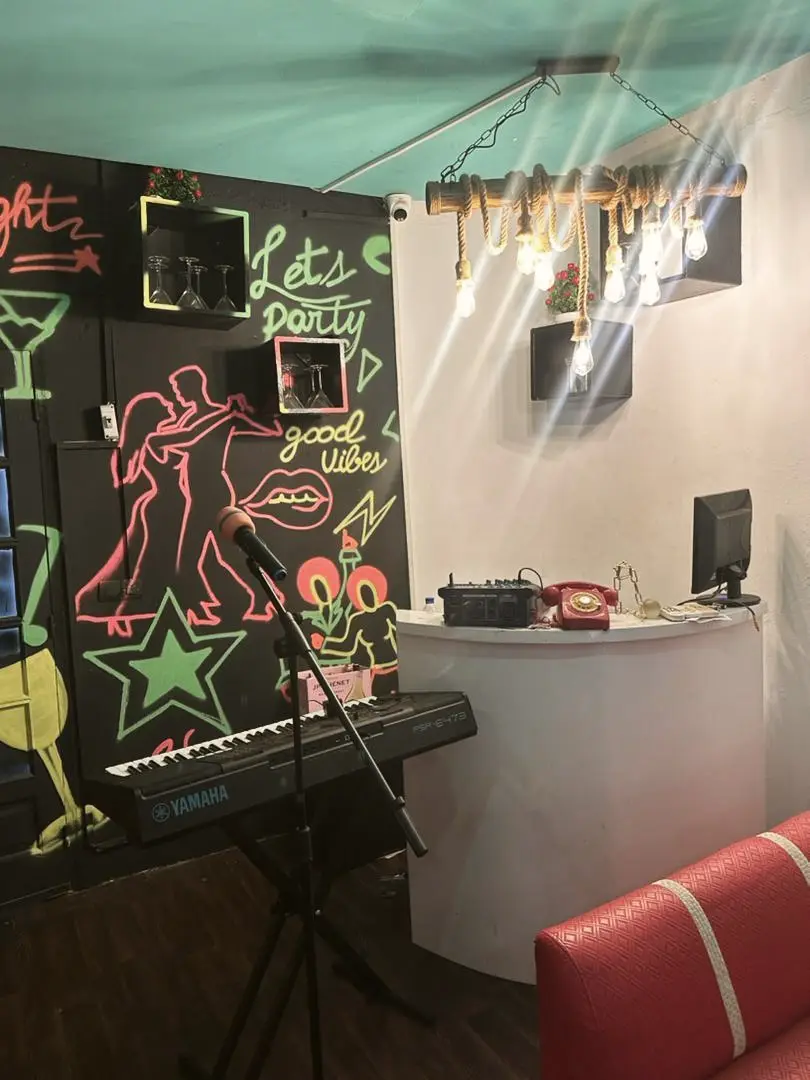 Coin scène avec clavier, micro et mur graphique « Let’s party »